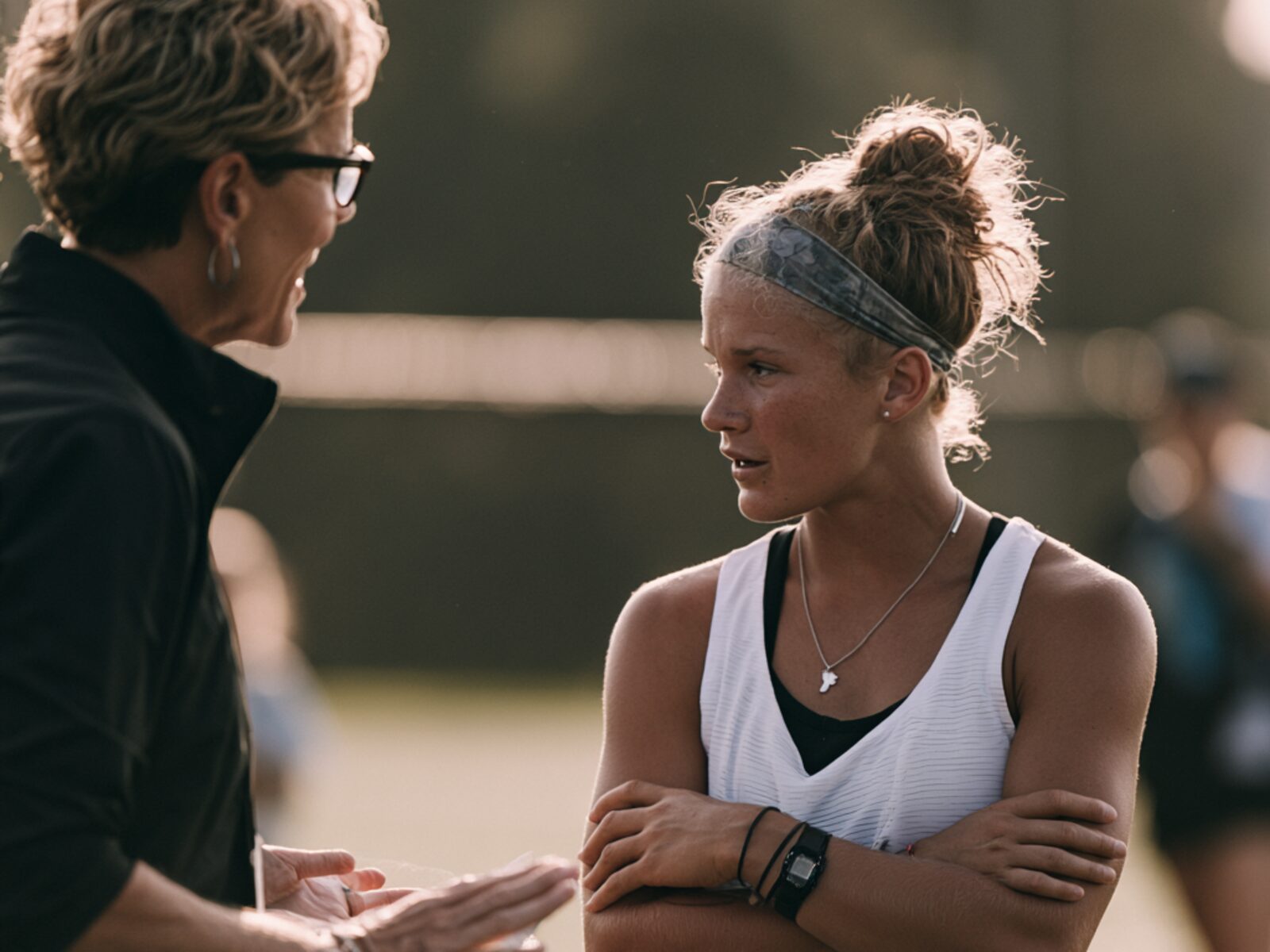 A coach talking through the work with a young athlete after practice